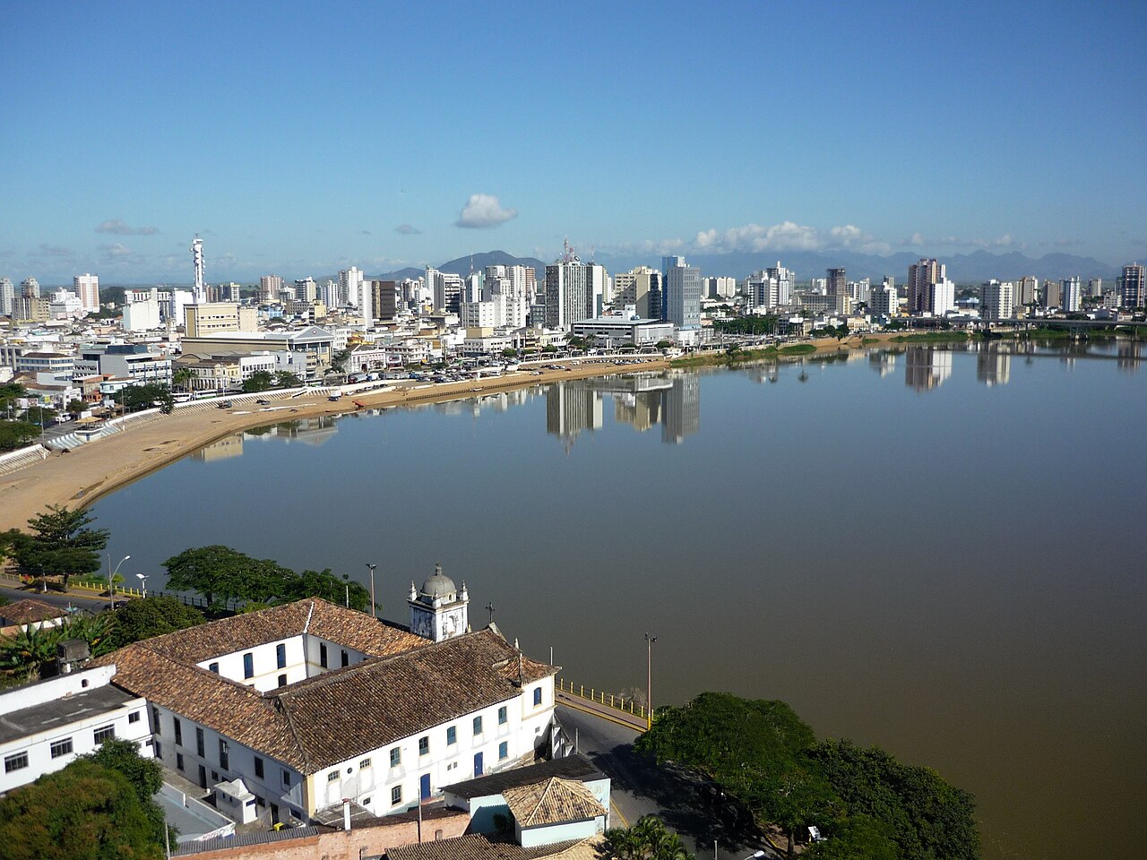 Vista do centro de Campos dos Goytacazes, Rio de Janeiro, com prédios às margens do rio Paraíba do Sul e casario histórico em primeiro plano